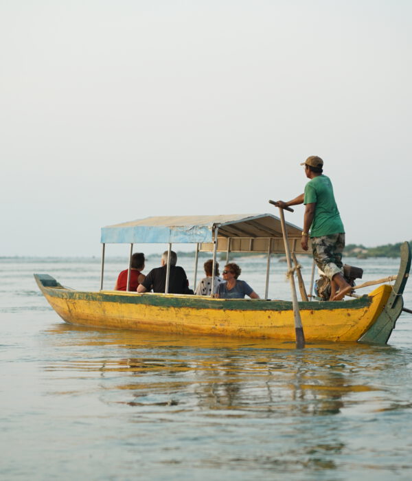 Foreigner riding a boat on the Mekong River, exploring Cambodia’s natural beauty of Mekong Dolphine